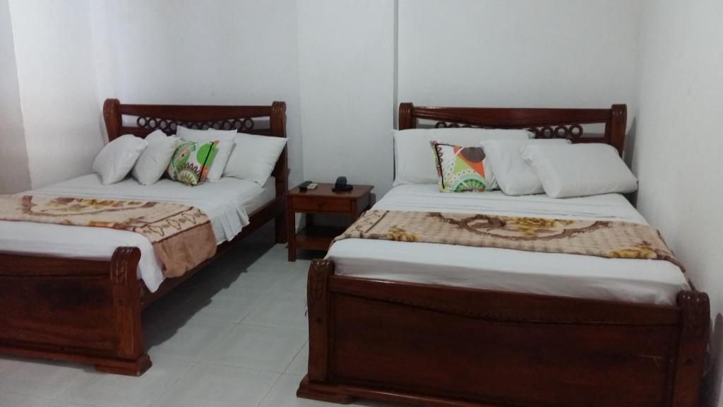 1 dormitorio con 2 camas y mesita de noche en Hotel Casa De España, en Mompox