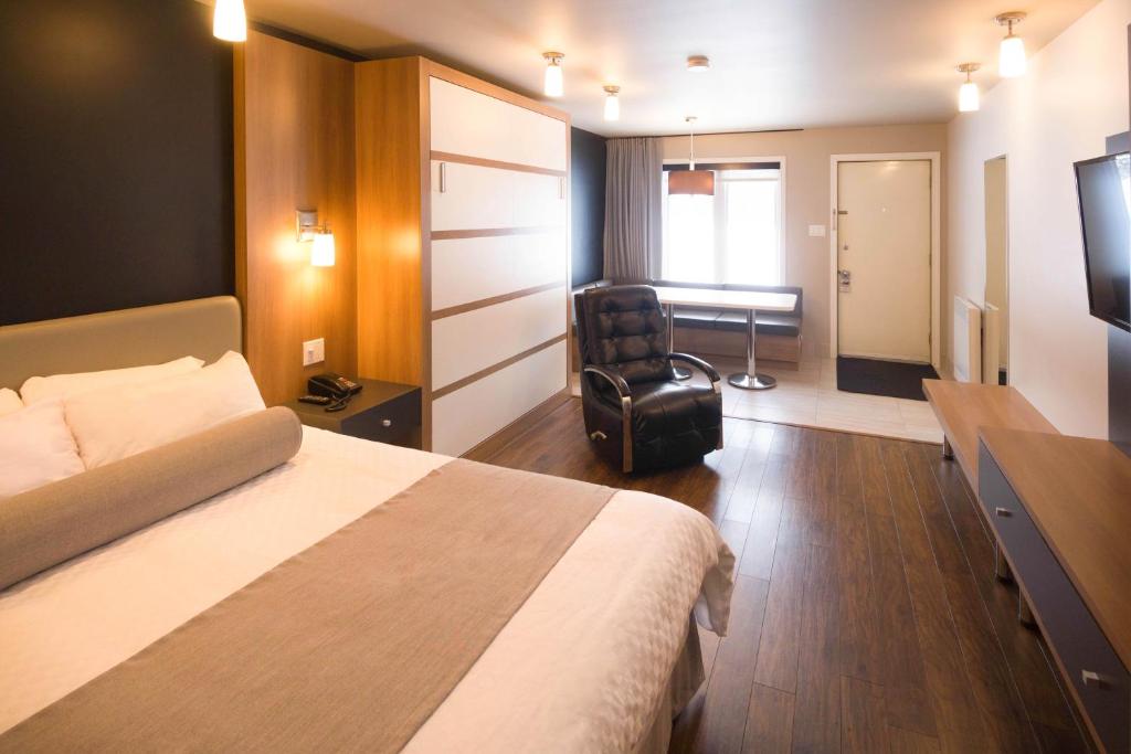 Hôtel Marineau La Tuque في لاتوك: غرفه فندقيه بسرير وكرسي