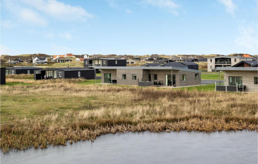 un grupo de casas junto a un cuerpo de agua en Holiday Home Ringkøbing 57, en Søndervig