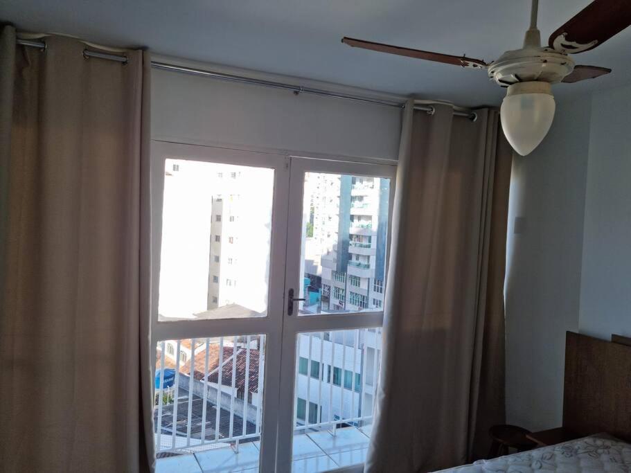 Un dormitorio con una ventana con vista a una ciudad. en Apartamento Centro Guarapari- ES, en Guarapari