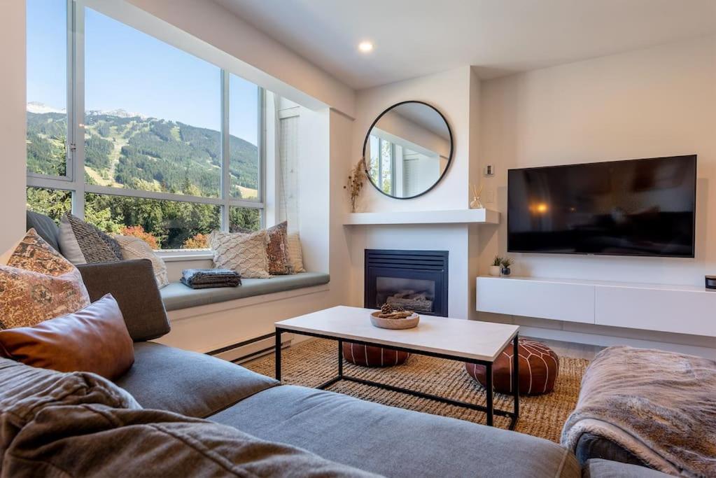 a living room with a couch and a fireplace at Location with Views - 2BDR Penthouse Whistler Village in Whistler
