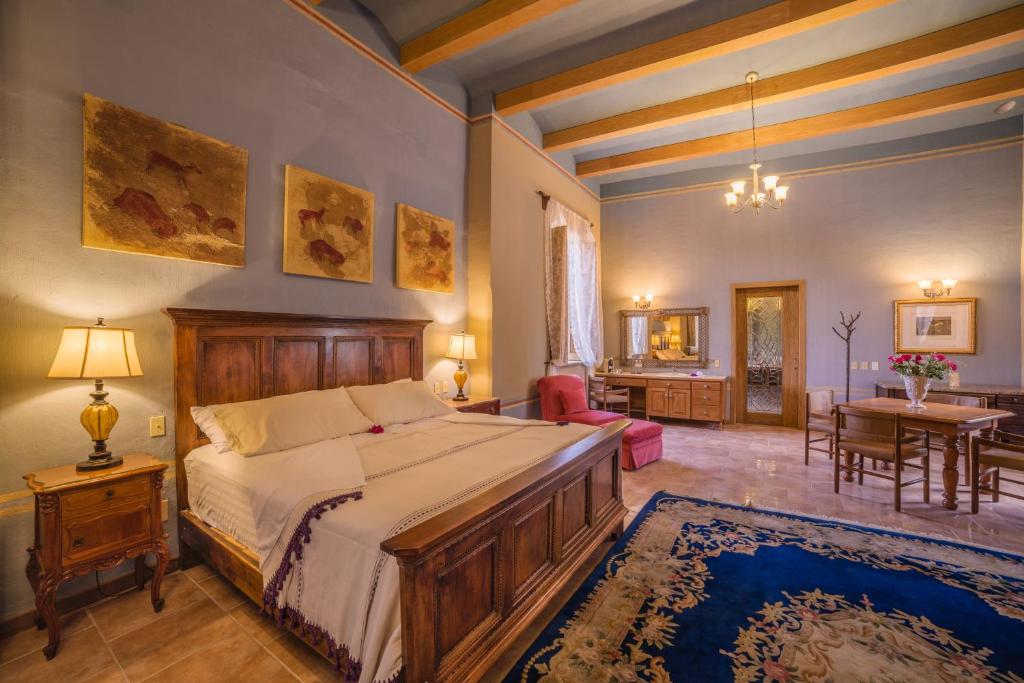 1 dormitorio con 1 cama grande y sala de estar en Hacienda Labor de Rivera Hotel Boutique, en Teuchitlán