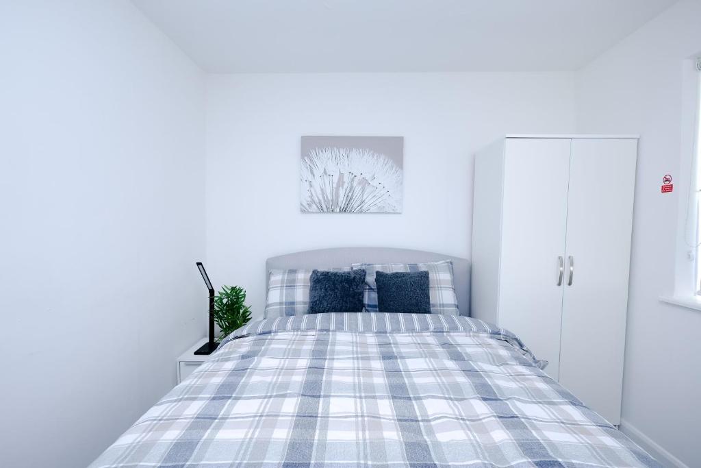 a white bedroom with a bed with blue pillows at Hope Deluxe King Bedroom Manchester in Middleton