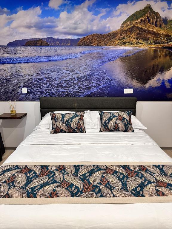 a bed in a room with a painting of the ocean at Ononui Lodge Airport, Ocean-View, Private Bathroom and Balcony, Free WiFi and Parking, On-Site Car Rental in Faaa