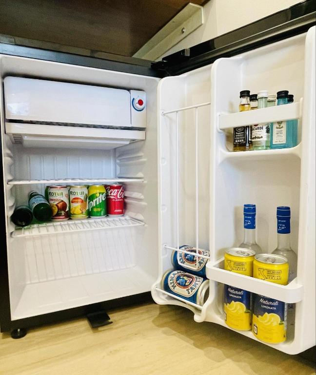 an open refrigerator filled with lots of food and drinks at Ononui Lodge Airport, Ocean-View, Private Bathroom and Balcony, Free WiFi and Parking, On-Site Car Rental in Faaa