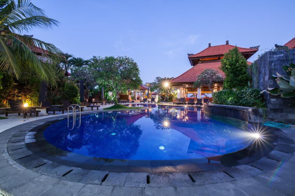 a swimming pool in a resort at night at Beach Front Hotel Danau Tamblingan St Sanur Bali in Sanur