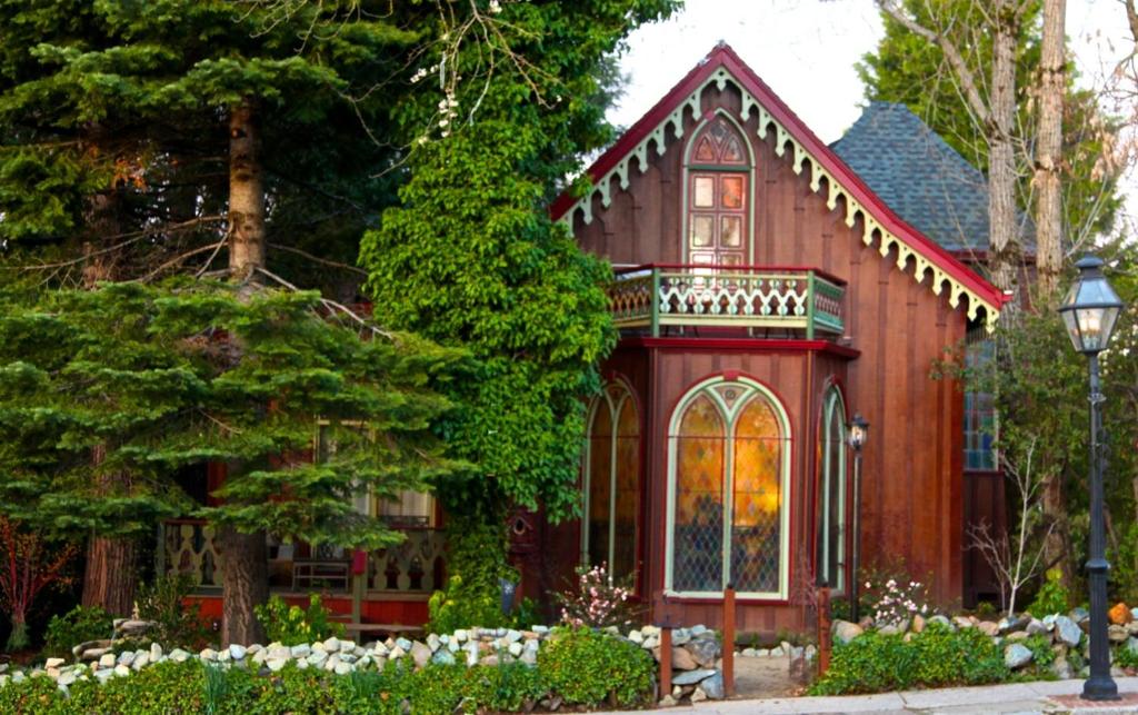 a red house with a balcony and trees at Two Room Inn in Nevada City