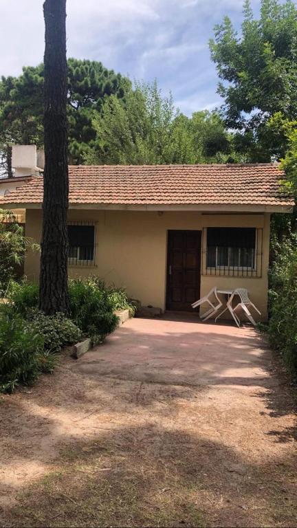 a house with a tree in front of it at Chalet zona del bosque in Valeria del Mar