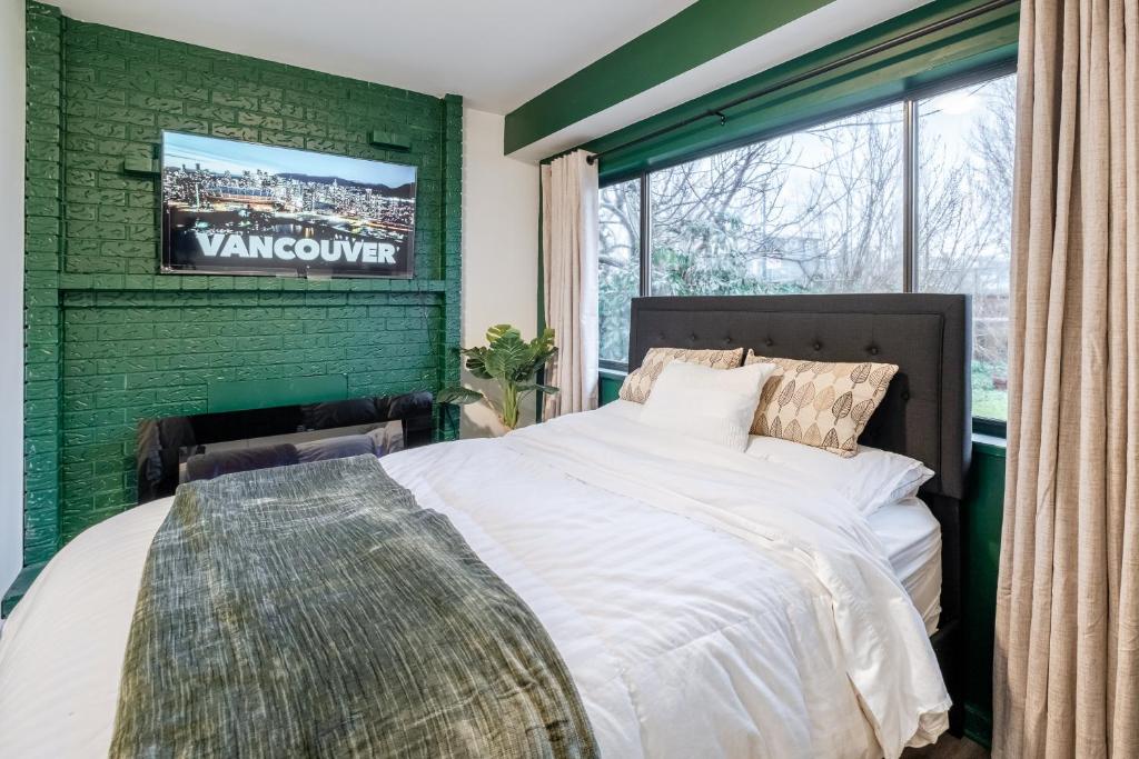a bedroom with green walls and a large bed at Vancouver Central Green Studio in Vancouver