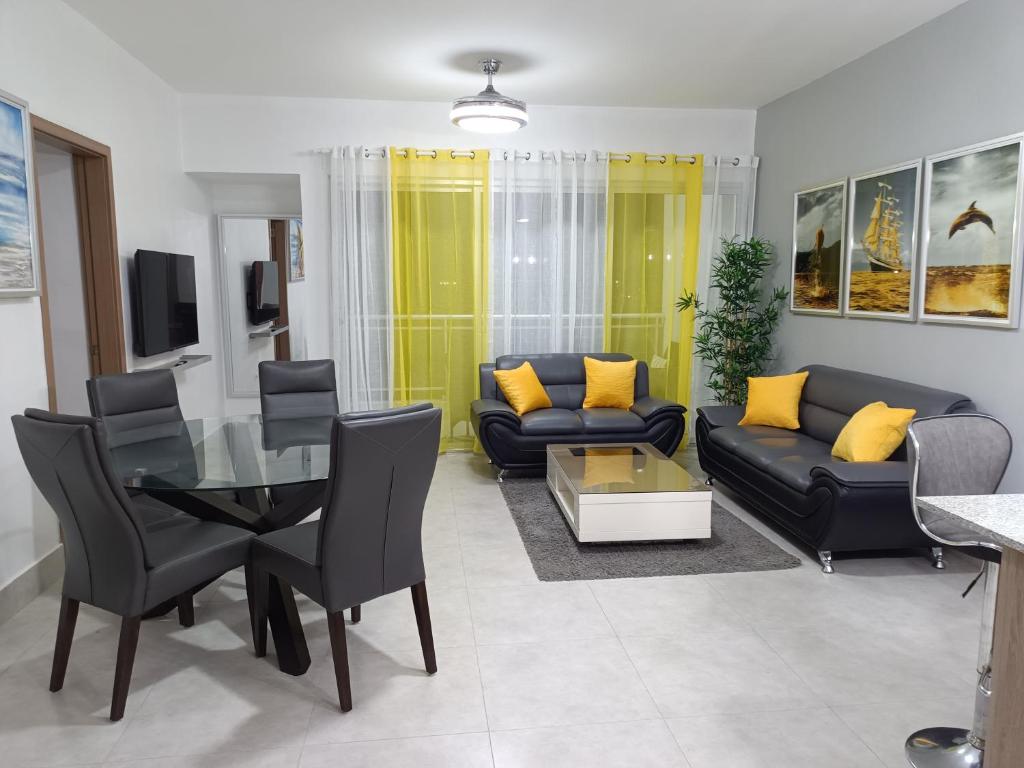sala de estar con sofá negro y almohadas amarillas en Boca del Mar III, apartamento 706A, en Boca Chica