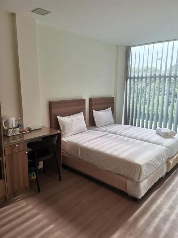 a bedroom with a bed and a desk and a window at SCC Velodrome KL in Kuala Lumpur