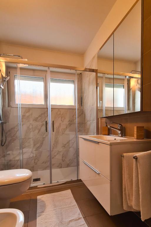 a bathroom with a shower and a toilet and a sink at Suite Apartment with a view and free parking in Lugano