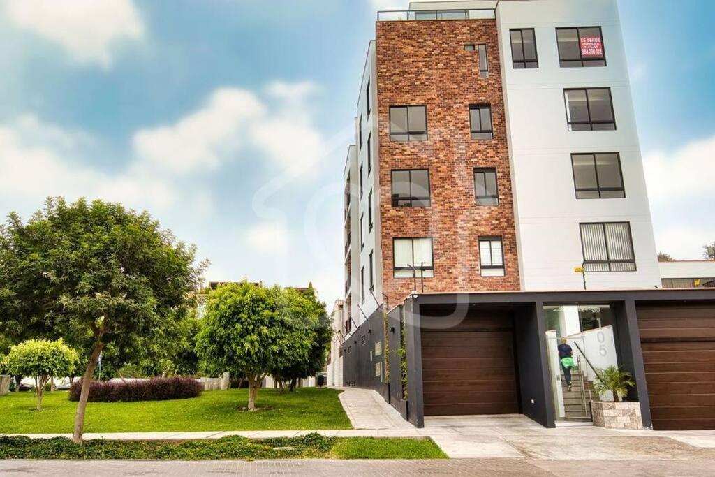a tall brick building with a garage at Lovely & quiet place, park view & private parking in Lima