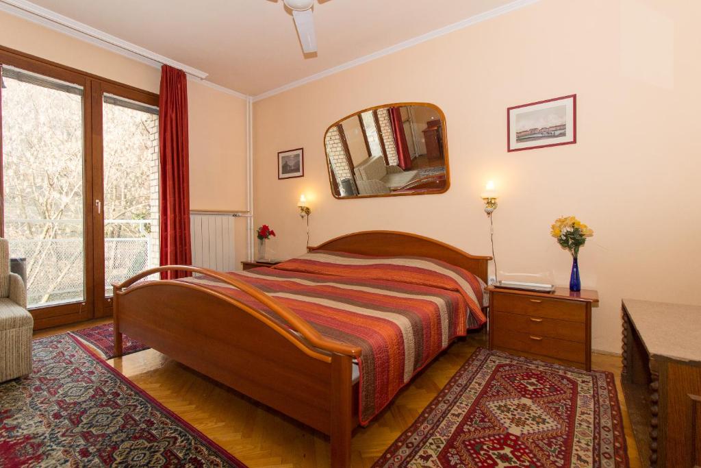 1 dormitorio con cama y espejo en la pared en Budavar Bed and Breakfast en Budapest