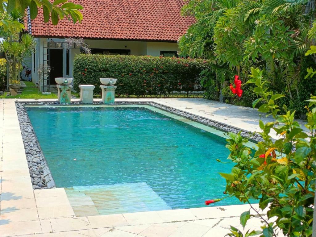 a swimming pool in the middle of a yard at Sayang Taman Villas in Sanur