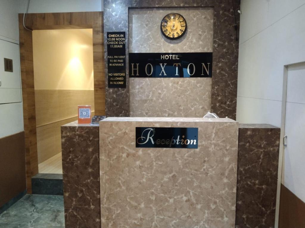 a hotel lobby with a clock on a wall at Hotel Hoxton in Mumbai