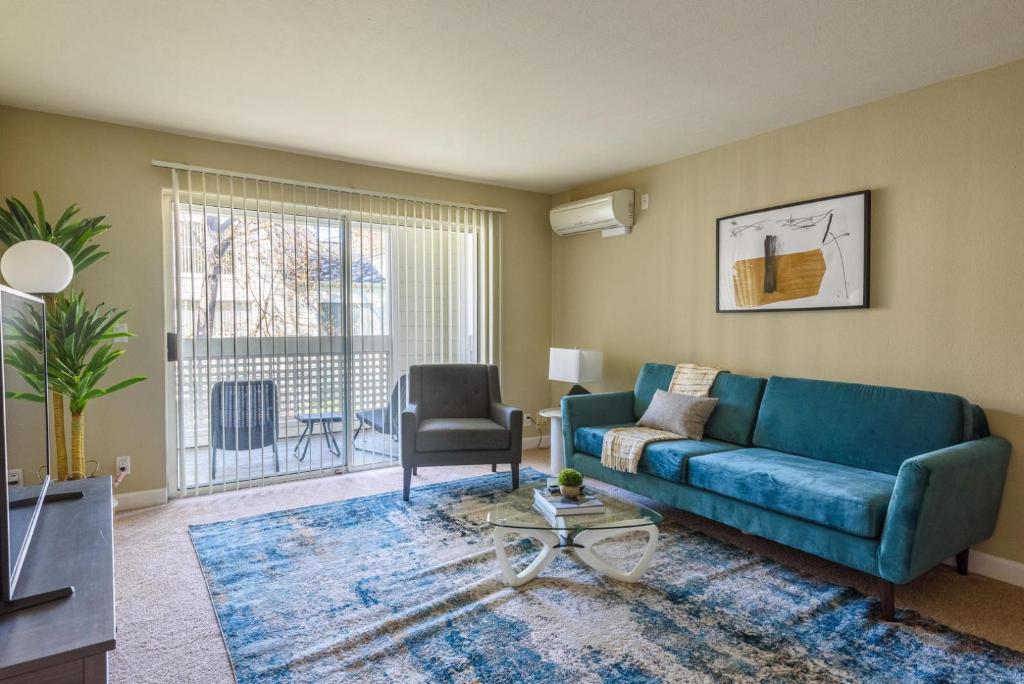 a living room with a blue couch and a chair at Blueground Santa Clara pool nr tech hub shops SFO-1672 in Santa Clara