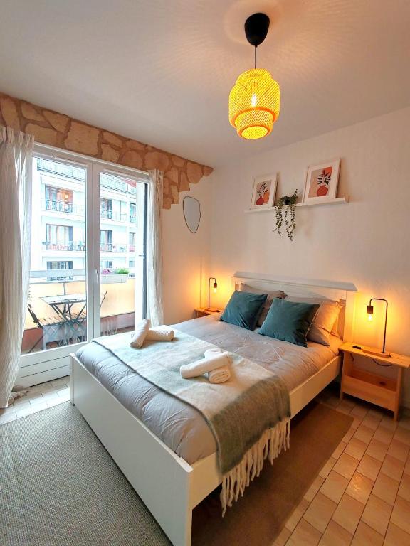 une chambre avec un grand lit avec une grande fenêtre dans l'établissement Veronese, à Annecy