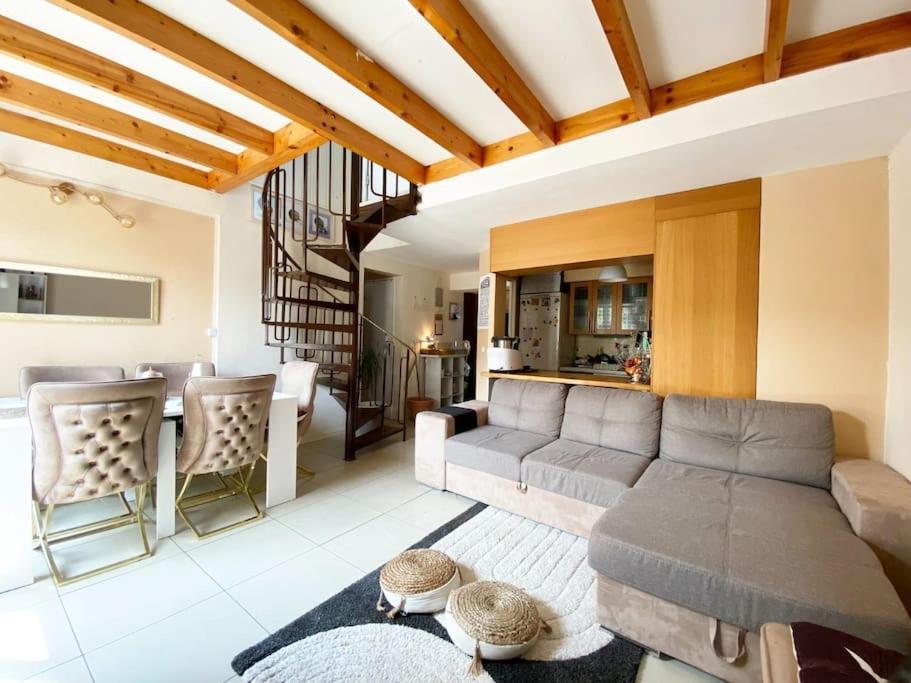 un salon avec un canapé et une table dans l'établissement Agréable Duplex de type F4, à Sevran