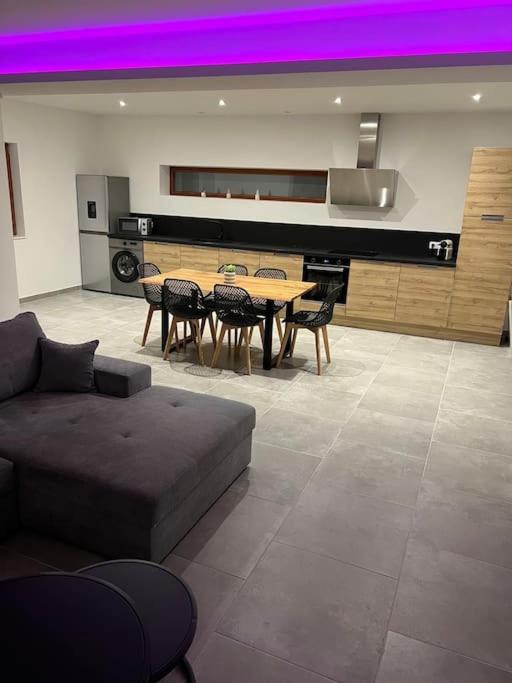 - un salon avec un canapé, une table et un piano dans l'établissement Appartement Le Belarya, à Wintzenheim