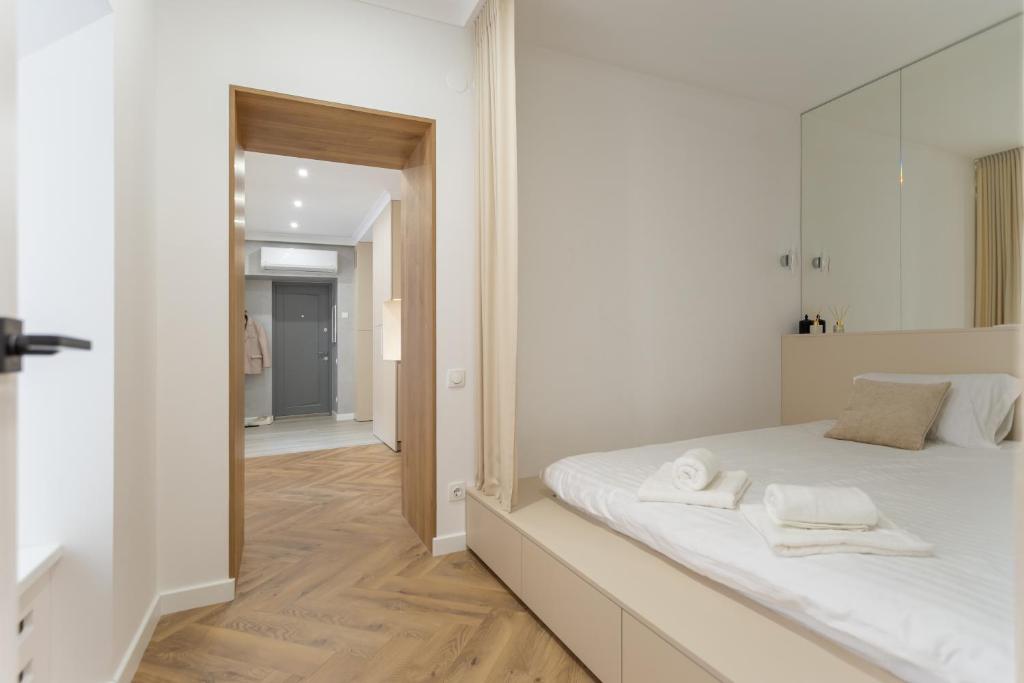 una camera da letto con un grande letto bianco con asciugamani sopra di M&D ApartmentsLviv, Andreolli Passage, Rynok Square 4person a Lviv