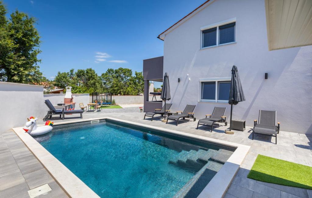 a swimming pool in front of a house at Ferienhaus Anton in Peroj