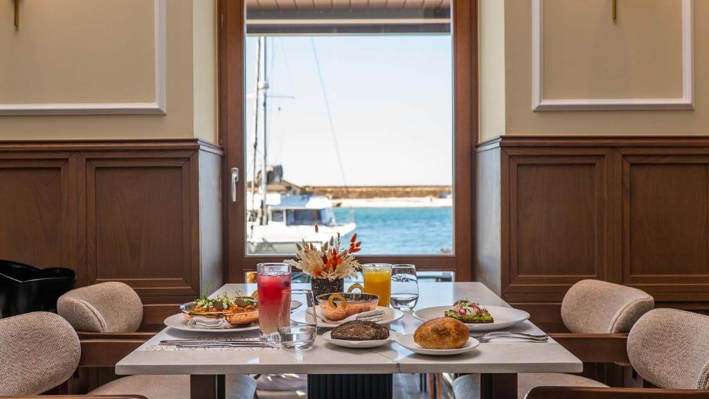 een tafel met eten erop met uitzicht op de oceaan bij MiraVita Boutique Hotel - Adults Only in Chania