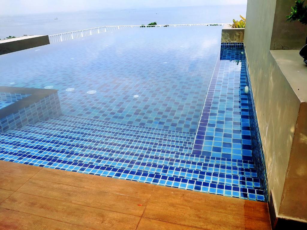 a swimming pool with blue tiles on the floor at Lucky Room in Ban Bang Saen (1)