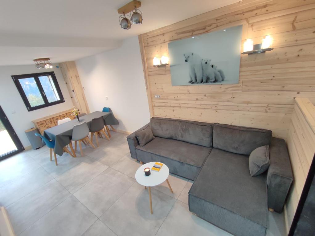 a living room with a couch and a table at Le Bois Cosy appartement 4 étoiles 6 personnes, ACCES SKI ALPE D'HUEZ GRAND DOMAINE A 3 K M in Allemont