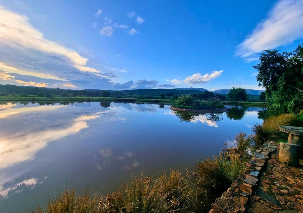 a view of a lake with clouds in the sky at Imbabali Retreat & Venue in Magaliesburg