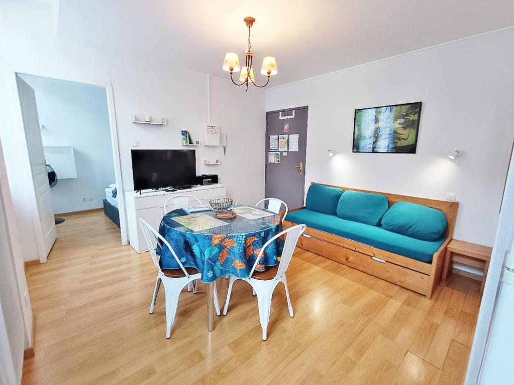 un salon avec un canapé bleu et une table dans l'établissement Val Montalban, T2 wifi, 4 pers, ascenseur, casier à ski, à Luchon