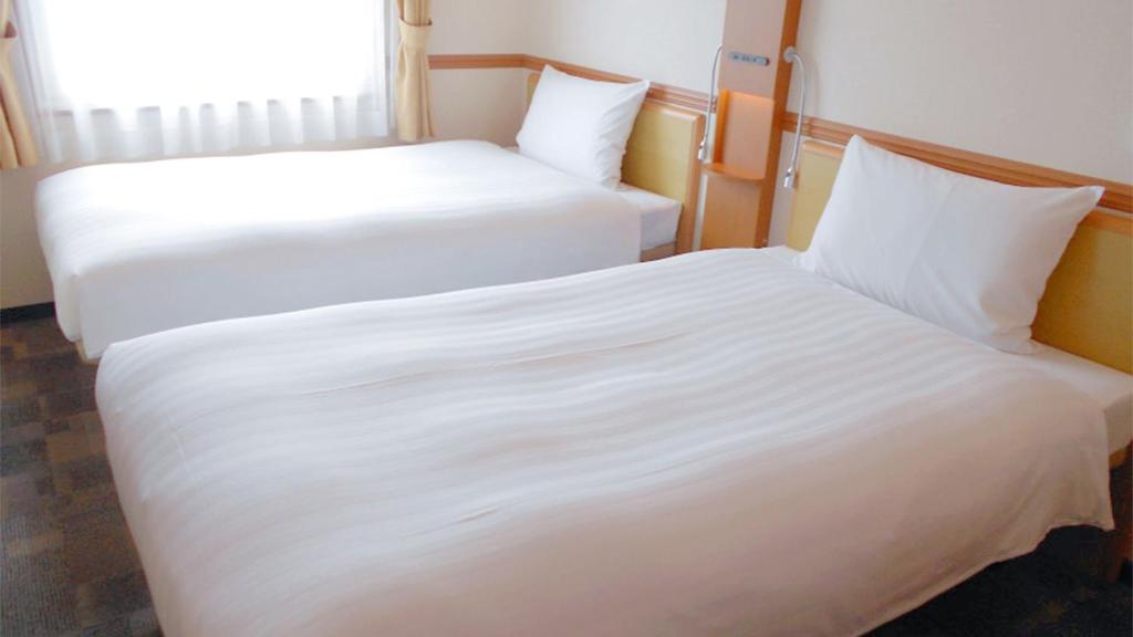 Postel nebo postele na pokoji v ubytování Toyoko Inn Shin-yamaguchi-eki Shinkansen-guchi