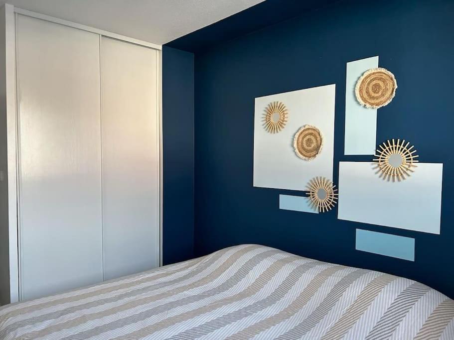 une chambre avec un mur bleu avec un lit dans l'établissement cosy T2, 3pers, 2 lits, parking privée, wifi, à Agen