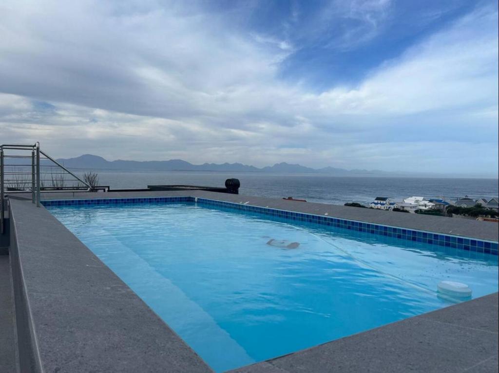 una piscina con el océano al fondo en Retro Rhythm - Mossel Cove, en Mossel Bay