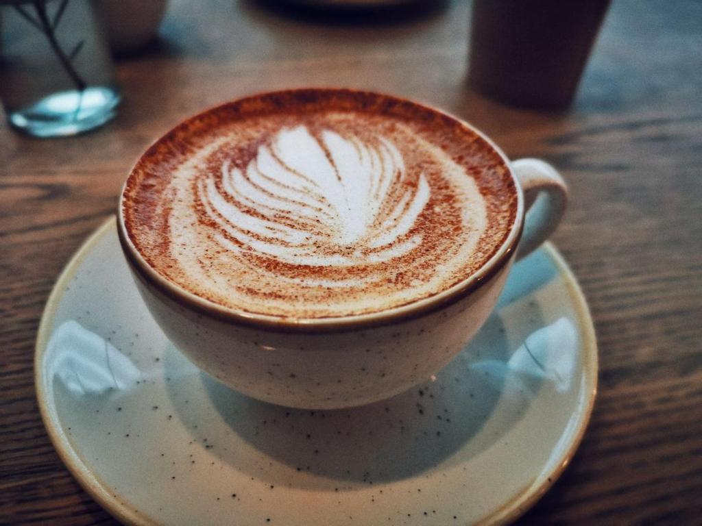 una tazza di caffè su un piatto su un tavolo di Patan Square - 2 km from Patan Durbar Square a Patan