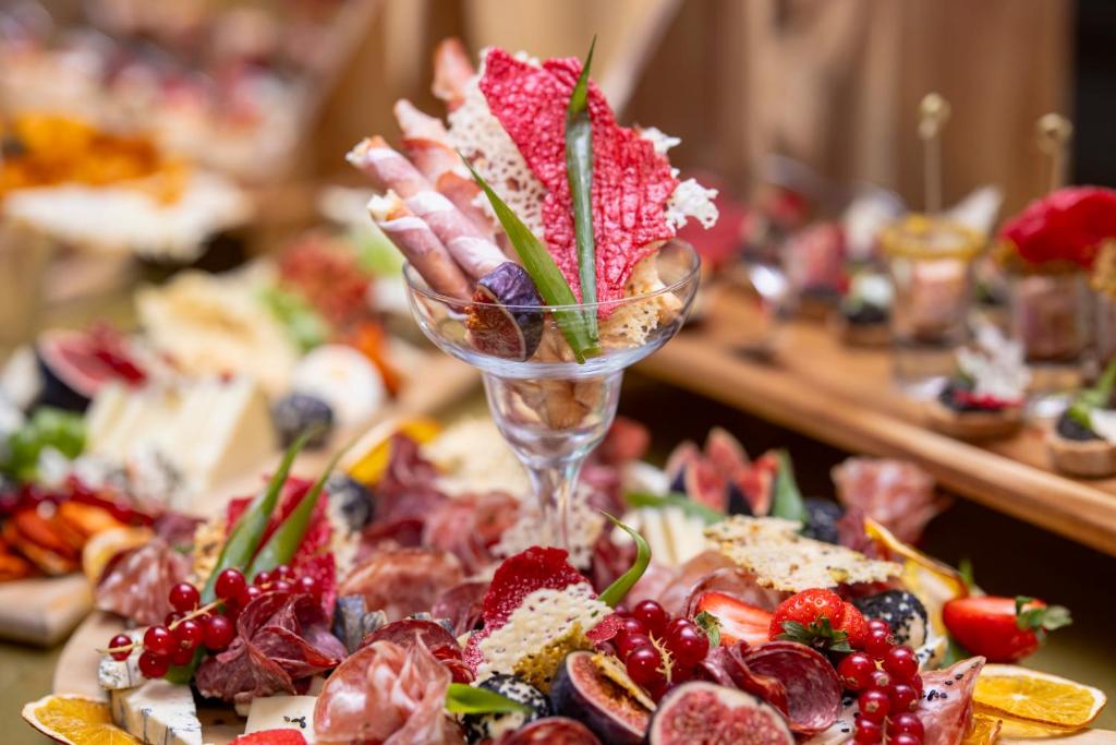 a table topped with a plate of food with a wine glass at Pullman Bucharest World Trade Center in Bucharest