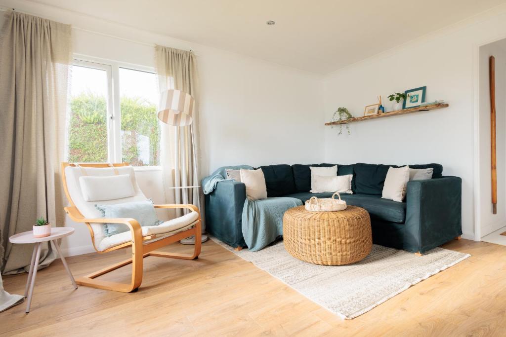 una sala de estar con un sofá y una silla en Secluded Sanctuary On The River, en Christchurch