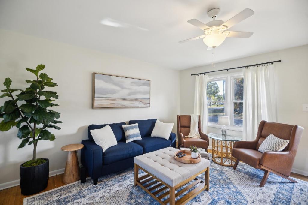 a living room with a blue couch and chairs at Comfy Coastal Getaway with Modern Comforts home in Hampton