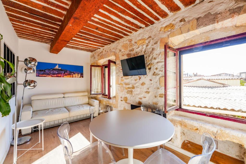 un salon avec une table et une fenêtre dans l'établissement L'Agora - Proche Pharo, Vieux port, Saint-Victor Noailles, à Marseille