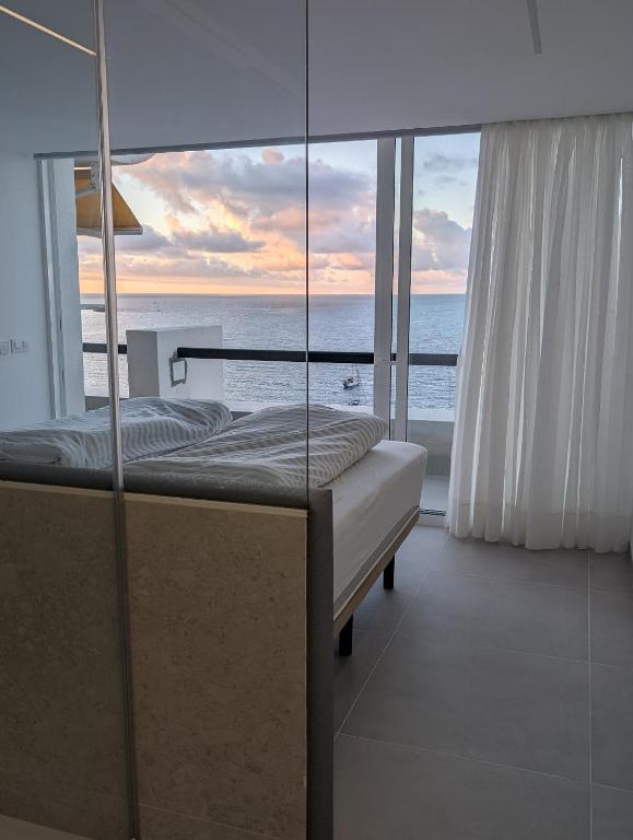 a bedroom with a bed and a view of the ocean at Sonido del mar Gran Canaria - Montemarina - luxury panoramic view in Mogán
