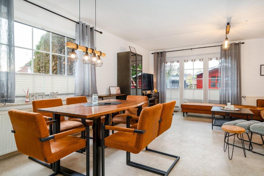 une salle à manger avec une table et des chaises dans l'établissement Von Manderley, Ferienhaus mit 3 Schlafzimmern und Garten, Hund willkommen!, à Greetsiel