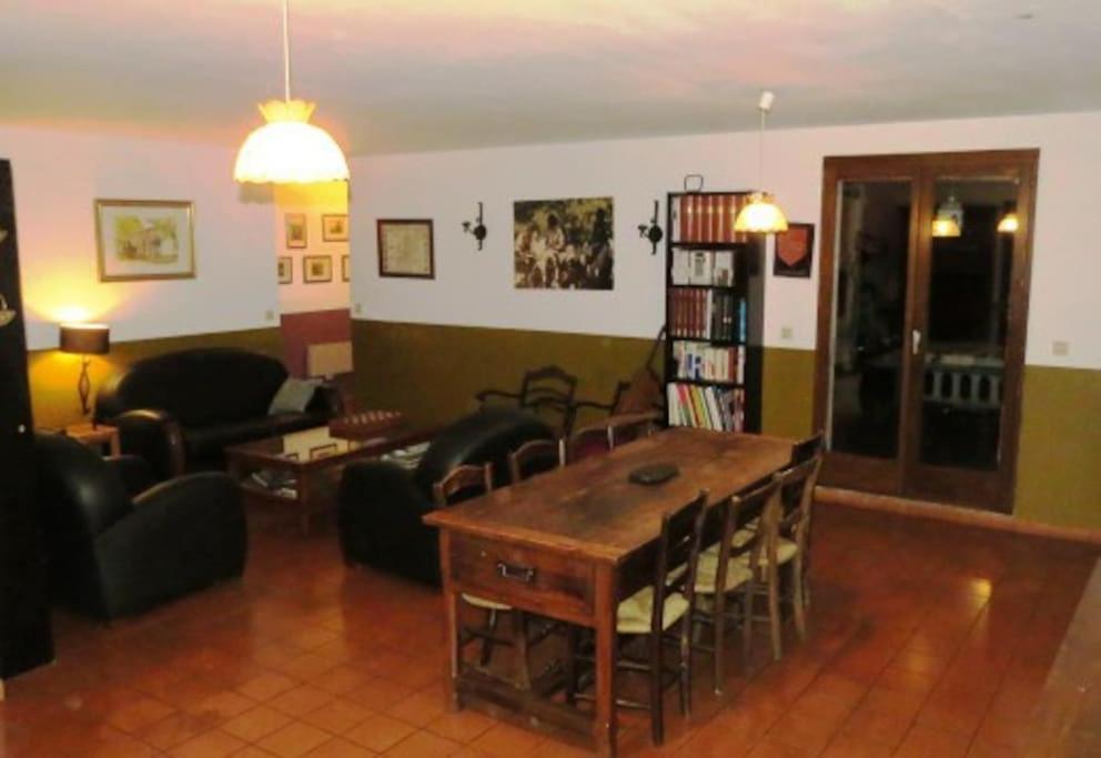 a living room with a wooden table and chairs at Maison 90m2 avec grand parc au bord de la rivière in Montredon-Labessonnié