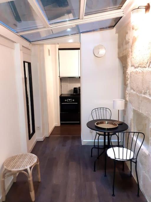 une pièce avec une table et des chaises et une cuisine dans l'établissement Studio atypique neuf Tourny hyper centre Bordeaux, à Bordeaux