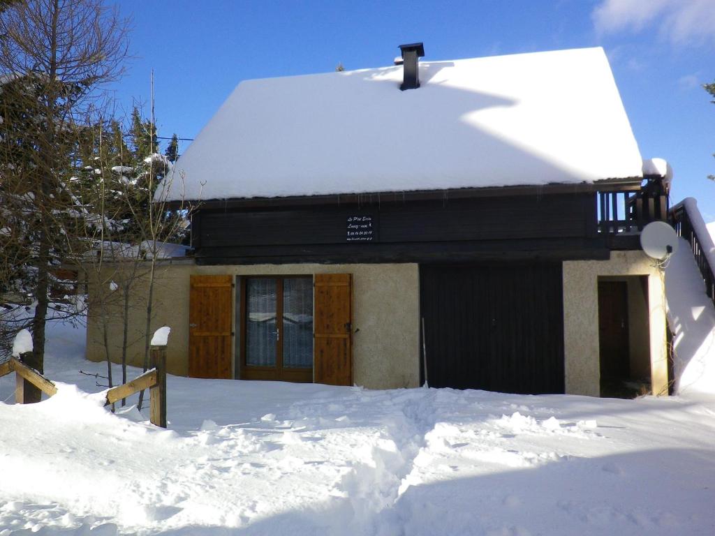 une maison recouverte de neige avec un tas de neige dans l'établissement Le Ptit Ecrin - Rez de chalet à Ancelle - 6pers 2ch - jardin, à Ancelle