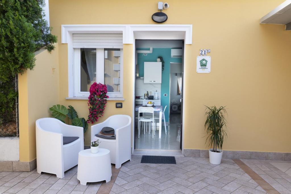 wejście do domu z dwoma krzesłami i stołem w obiekcie Residence Yellow w Rimini