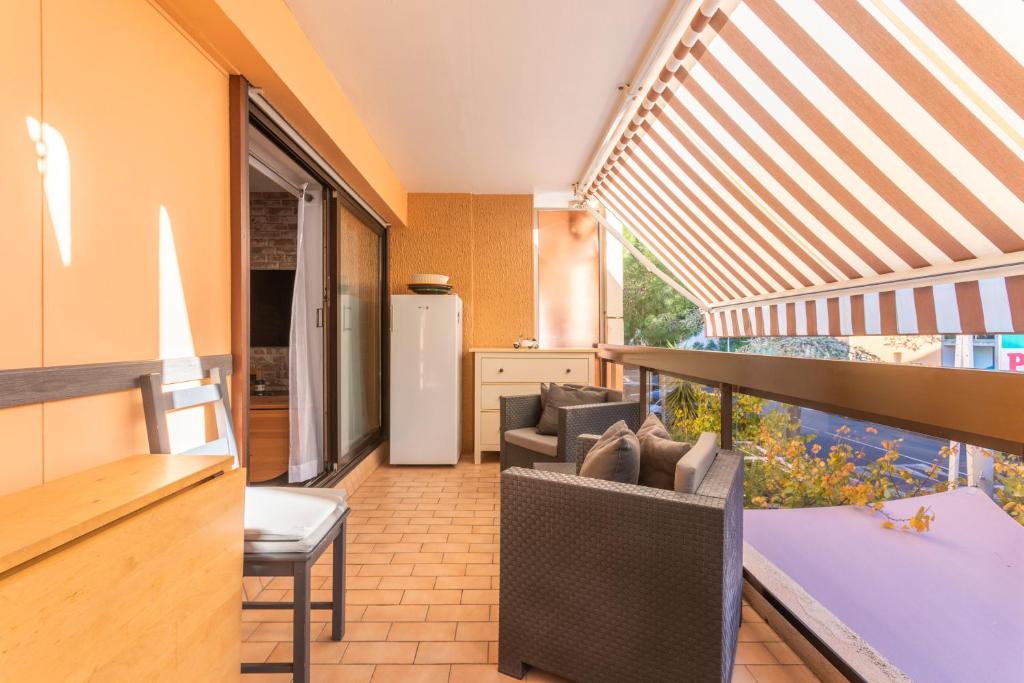 a room with a balcony with a table and chairs at La Favière proche de la plage in Bormes-les-Mimosas