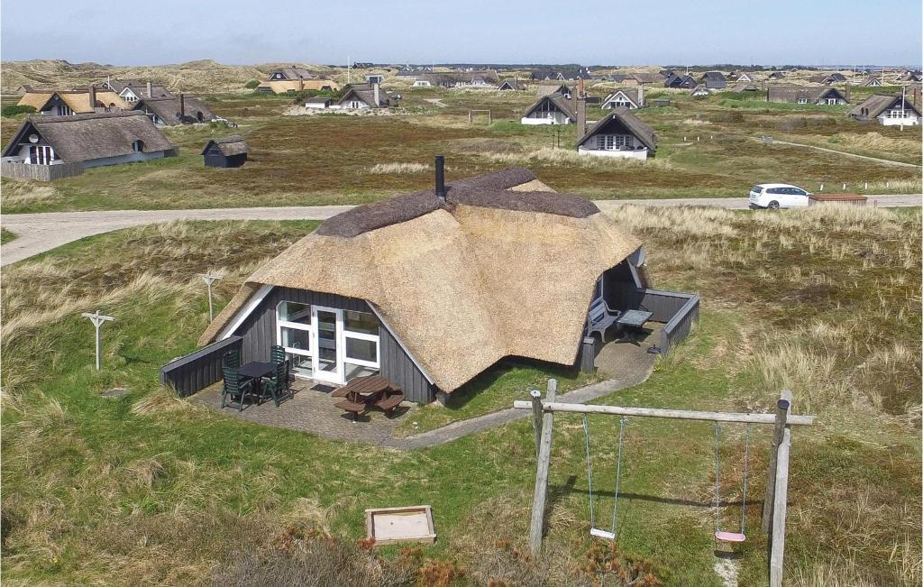 ein kleines Haus mit einem Strohdach auf einem Feld in der Unterkunft Holiday Home Nordsø Ferievej Ii in Nørre Lyngvig