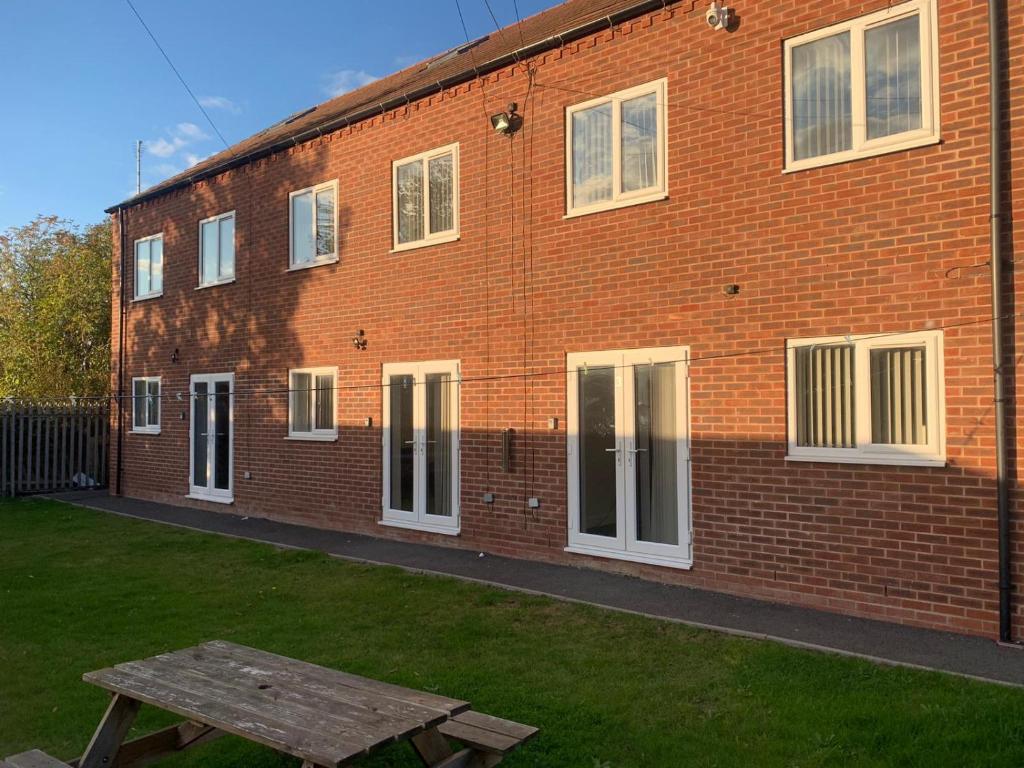a brick building with a picnic table in front of it at 4 Bedroom Contractors House in Sheffield