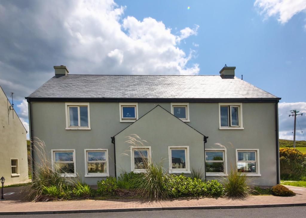 a large house with a gray roof at Doolin Village Lodges in Doolin