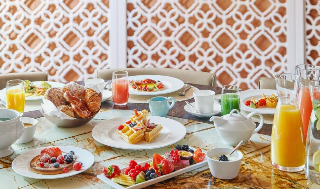 a table with plates of breakfast foods and drinks at Mandarin Oriental, Munich in Munich
